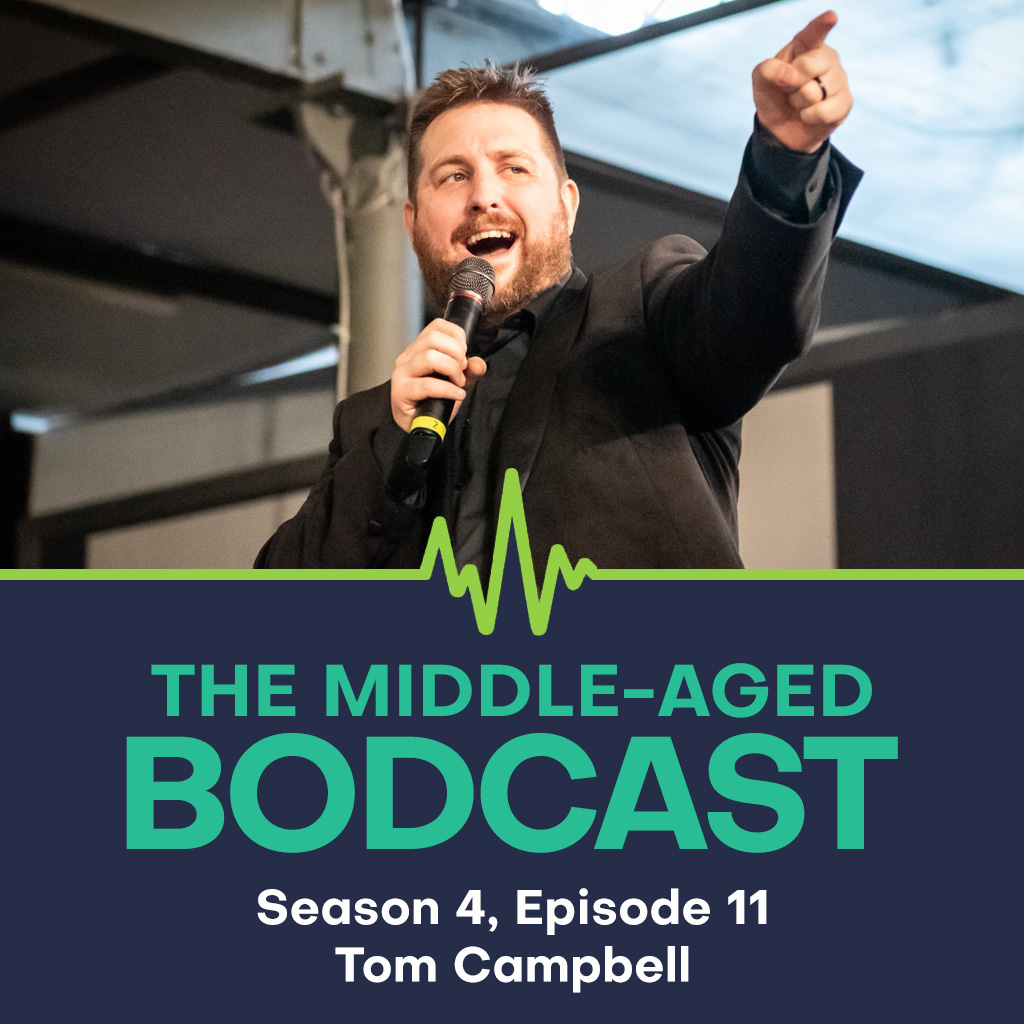 Tom Campbell, presenter from Cultaholic Wrestling, stands on in a wrestling ring in a black suit, bearded and animated, pointing and speaking into a microphone. Below the image is The Middle-aged Bodcast logo with the text: "Season 4, Episode 11 – Tom Campbell".